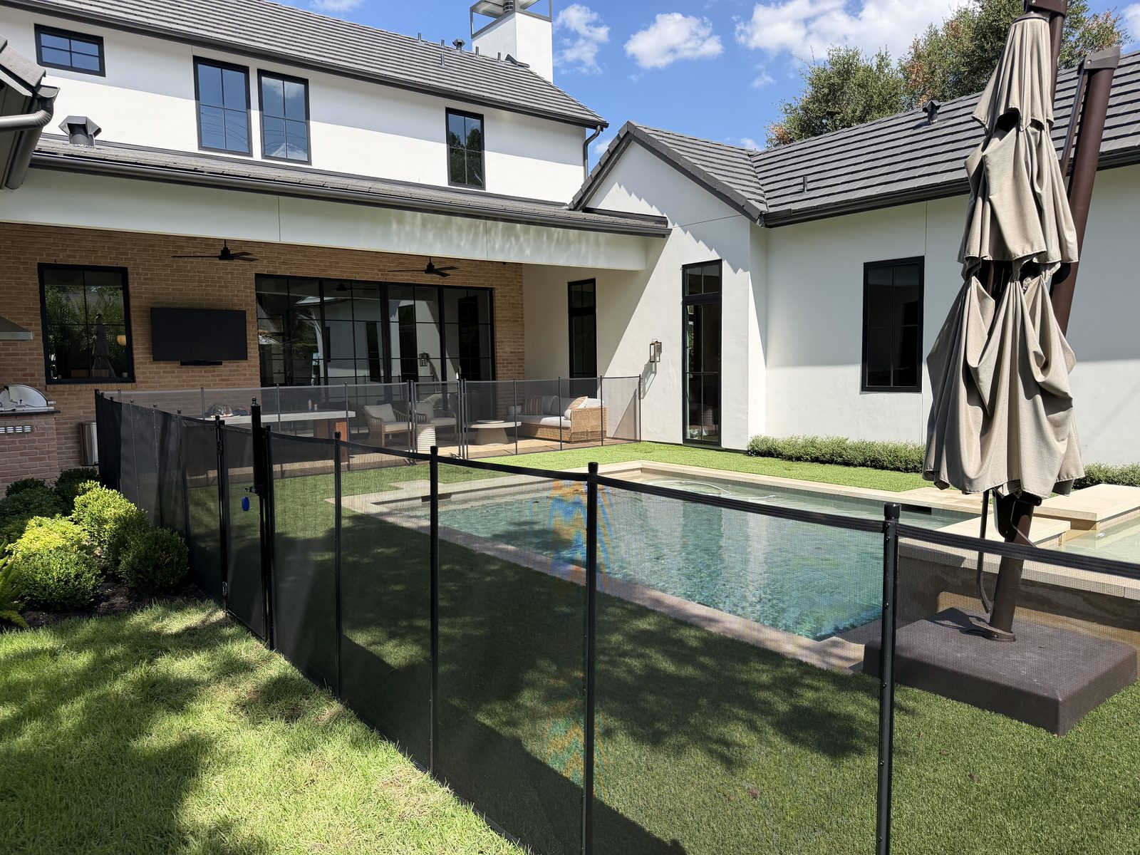 Removable mesh pool fence with a self-closing safety gate around a rectangular pool in the Allandale neighborhood of Austin TX, All-Safe certified