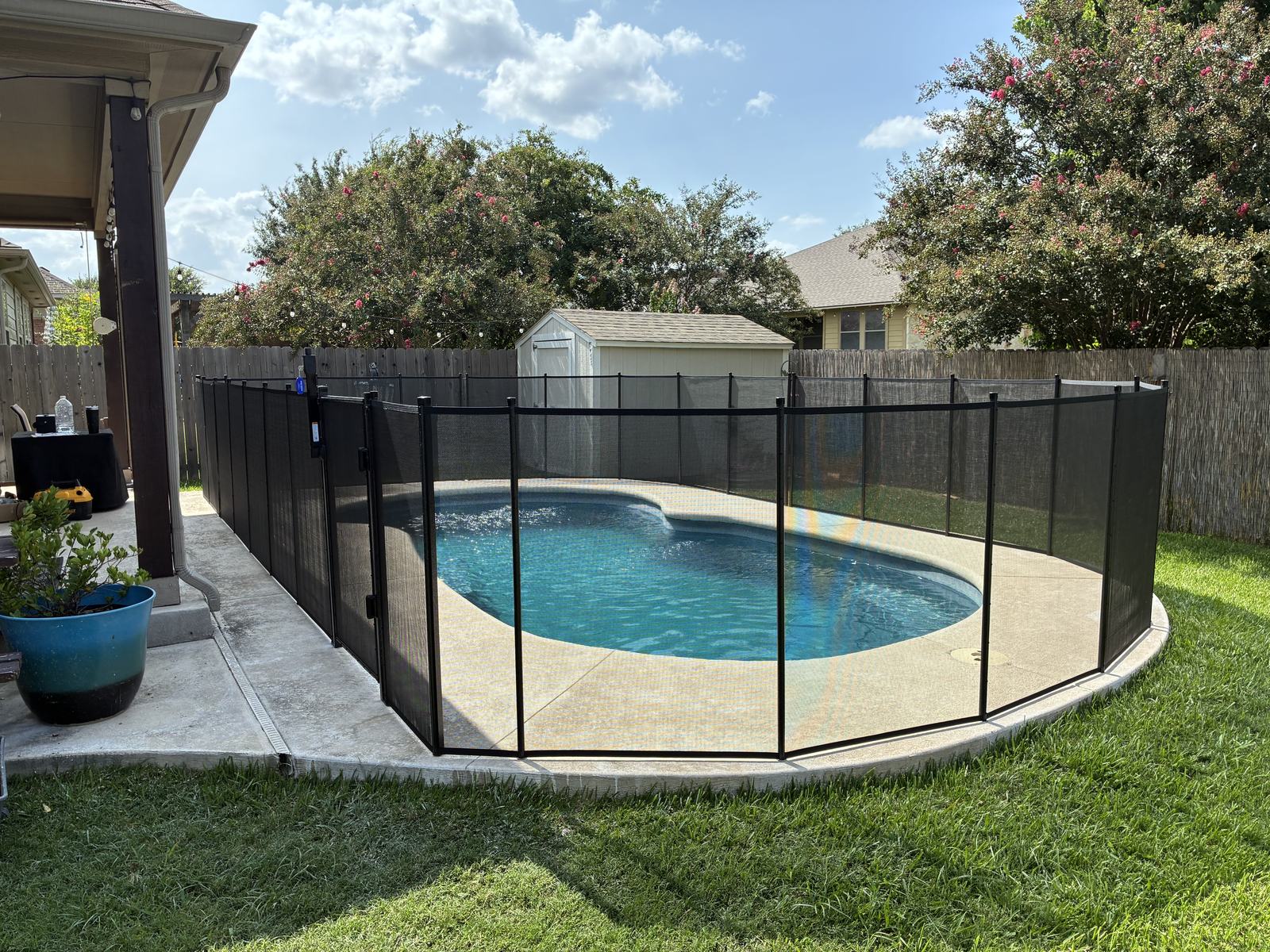 Removable mesh pool fence with a self-closing safety gate around a freeform pool in Buda TX, All-Safe certified