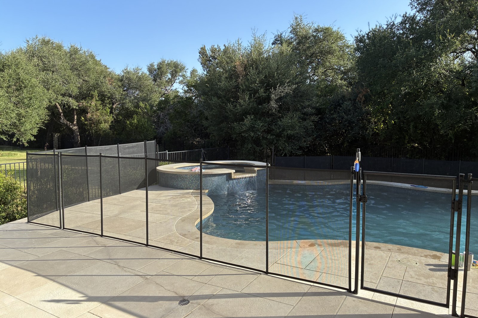 Removable mesh pool fence around a freeform pool and spa in the Circle C neighborhood of Austin TX, All-Safe certified