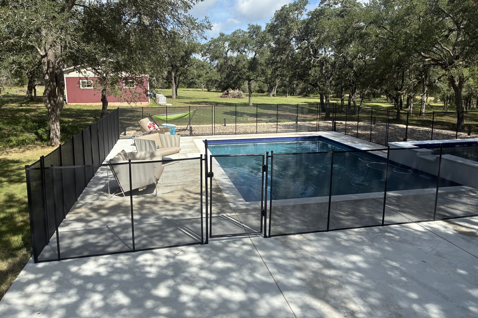 Removable mesh pool fence with self-closing safety gate around a Hill Country pool near Austin, All-Safe certified
