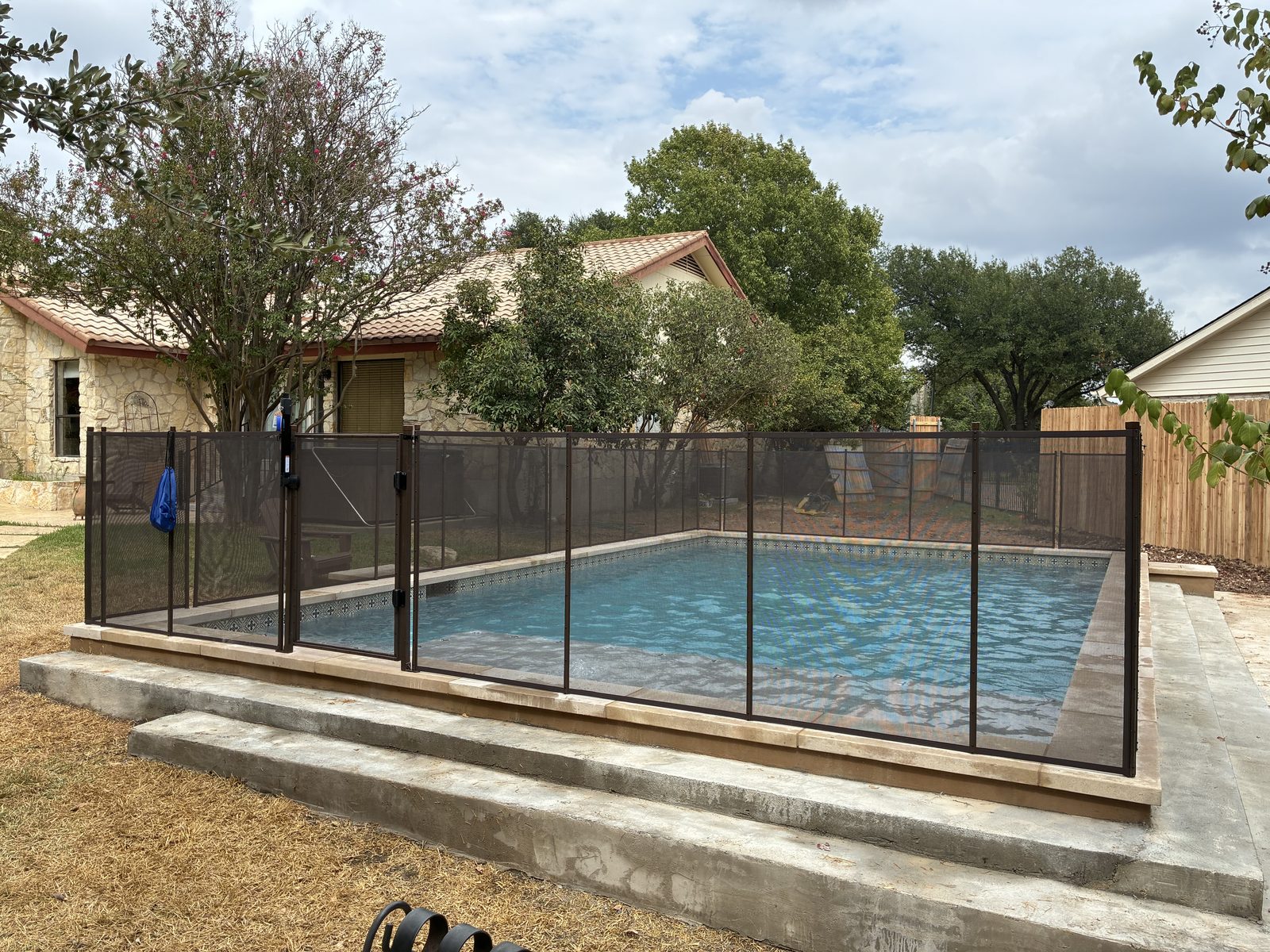 Removable mesh pool fence with a self-closing safety gate around a raised rectangular pool in Round Rock TX, All-Safe certified